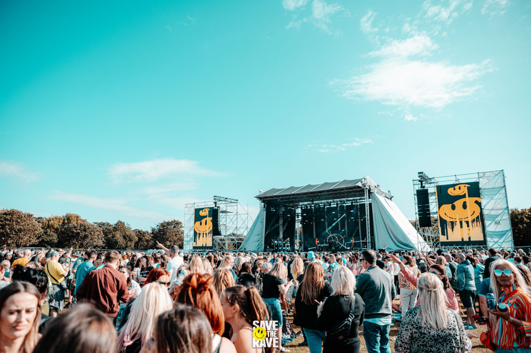 Audience at Save The Rave festival cheering with hands in the air facing the stage